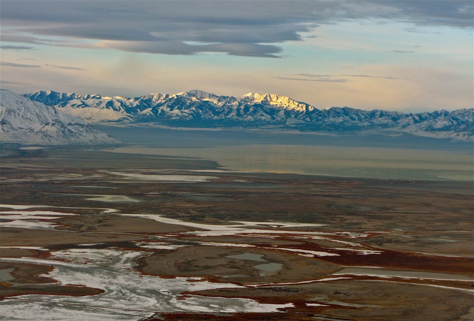 The Great Salt Lake and its wetlands stretching toward snow-lit peaks under a muted winter sky.